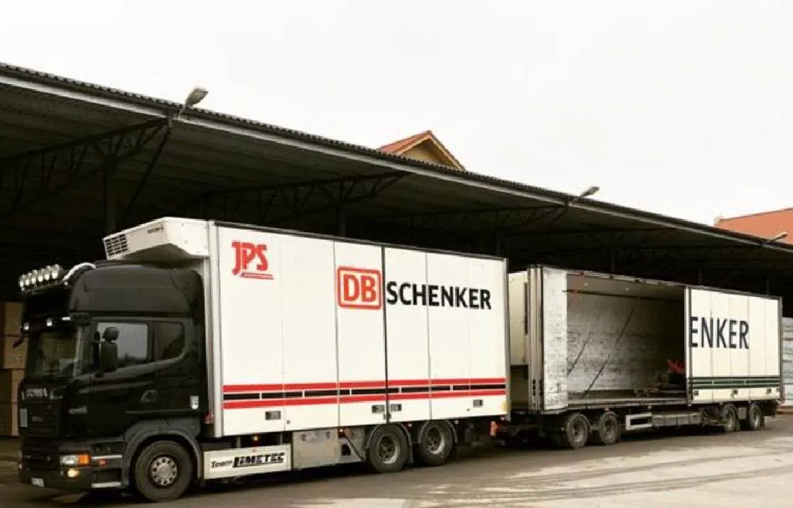 Scania med DB Schenker-skåp backad mot lastkajen under skärmtak.
