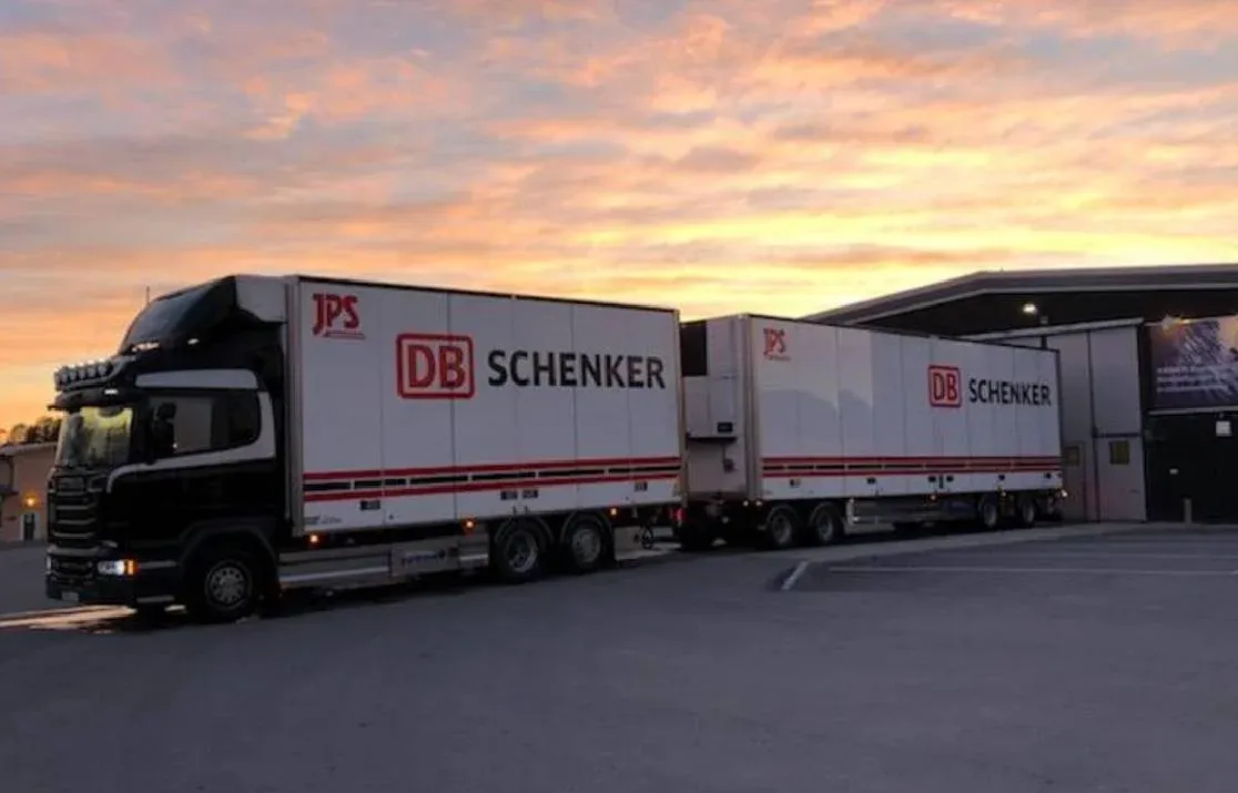 Ekipage med två DB Schenker-skåp uppställt i solnedgång.